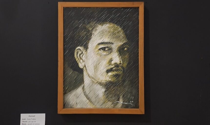 Framed charcoal portrait of a man with short hair and mustache, on a dark gallery wall.