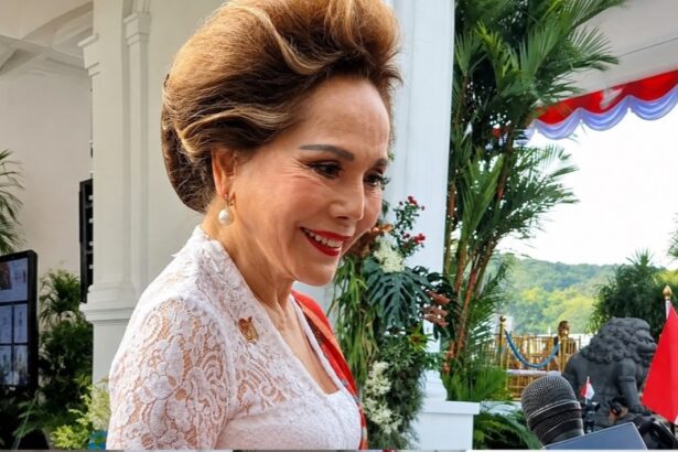 Woman in white lace dress being interviewed by reporters at an outdoor formal event.