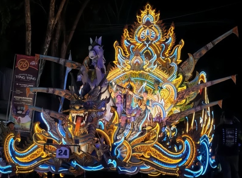Screenshot_20260912_222134_Instagram - Mabur.co Nighttime parade float: an intricately lit, multicolored dragon-themed sculpture with ornate gold and blue patterns, bearing a small number 24 badge at the front.