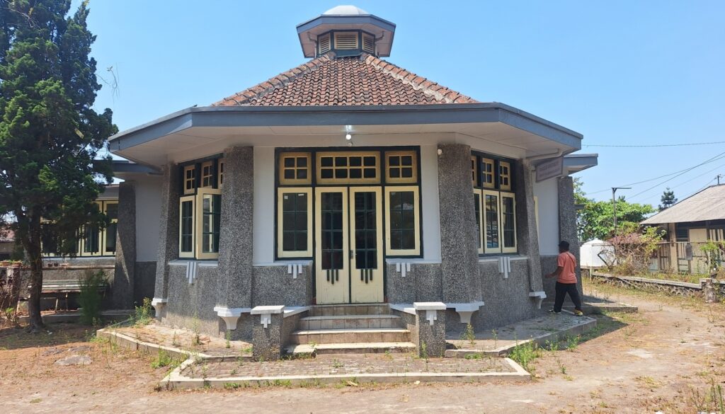 Screenshot_20260917_005853_Gallery - Mabur.co Small historic building with cream-framed windows and central double doors under a tiled roof, set on a stepped stone platform.