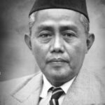 Black-and-white head-and-shoulders portrait of a middle-aged man wearing a suit, striped tie, and a traditional cap.