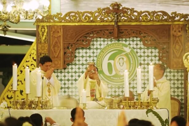 Priests in white robes perform a Catholic mass at an ornate altar, surrounded by lit candles and a gathered worshippers crowd.