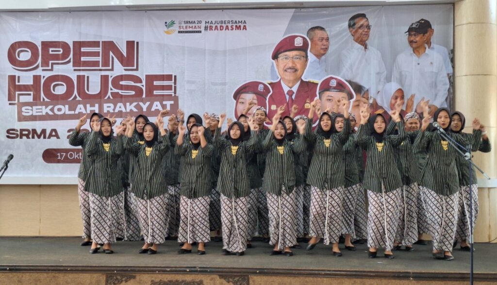 Screenshot_20261018_065031_Gallery - Mabur.co Female students in matching green striped uniforms singing on stage at an open house event, banner behind them reads 'OPEN HOUSE' and 'SEKOLAH RAKYAT'