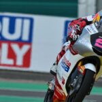 Motorcycle racer leaning into a turn on a race track with Liqui Moly banners in the background.