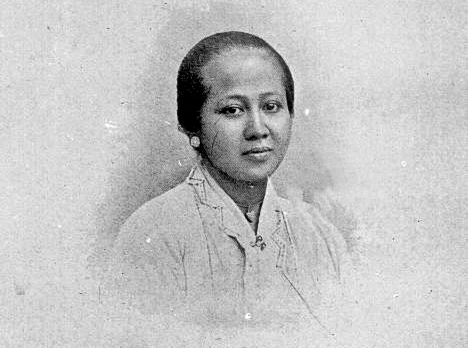 Black-and-white studio portrait of a woman with a neat bun, wearing a light blouse.