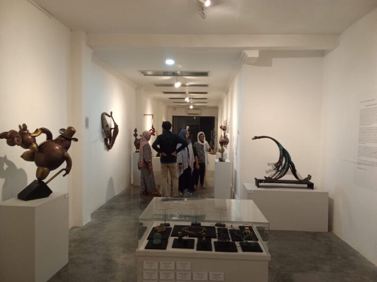 WhatsApp Image 2026-05-10 at 132218 1 - Mabur.co Group of visitors in a bright contemporary art gallery viewing abstract sculptures on plinths and display cases.