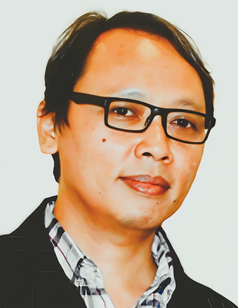 Close-up portrait of a person with short dark hair and black rectangular glasses.