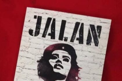 Stencil-style poster featuring a woman's portrait on a white brick background, tilted on a red surface; large text at top says 'JALAN KIRI' with additional text below.