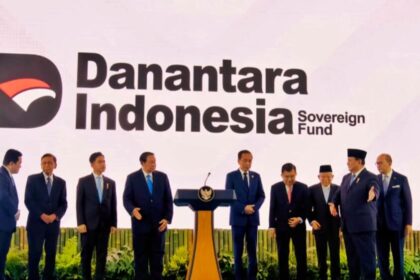 Group of officials in suits on a blue stage with a podium, in front of a Danantara Indonesia Sovereign Fund backdrop logo.