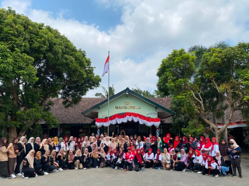 Large group of students and teachers posing for a photo in front of SDN Margorejo school, with an Indonesian flag and red-white bunting overhead.