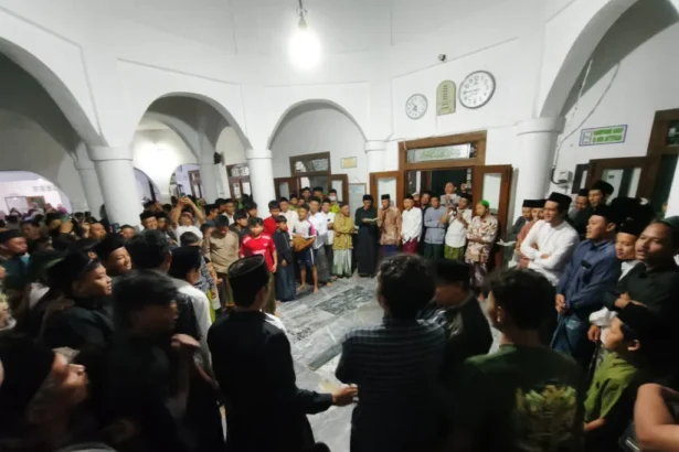 Large crowd of men and boys forming a circle in a white arched hall during a community gathering, center of attention unclear