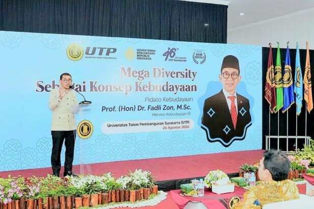 Speaker at a podium on a stage with a blue banner reading 'Mega Diversity' during a cultural event at Universitas Tunas Pembangunan Surakarta (UTP Surakarta).