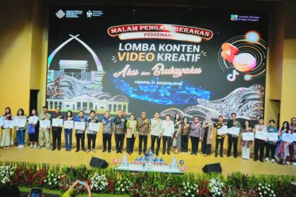 Group photo on stage after a creative video content competition, holding certificates with a large event banner behind them reading ‘Lomba Konten Video Kreatif’ (Jakarta, 2026).