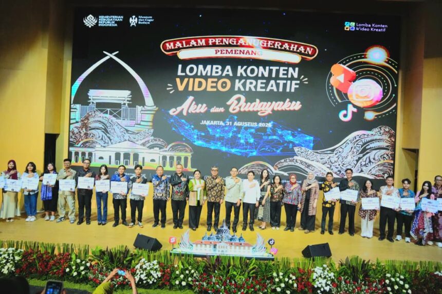 Group photo on stage after a creative video content competition, holding certificates with a large event banner behind them reading ‘Lomba Konten Video Kreatif’ (Jakarta, 2026).