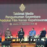 Six panelists seated on a stage during a Jakarta event with a large banner behind about a film production competition or theme.