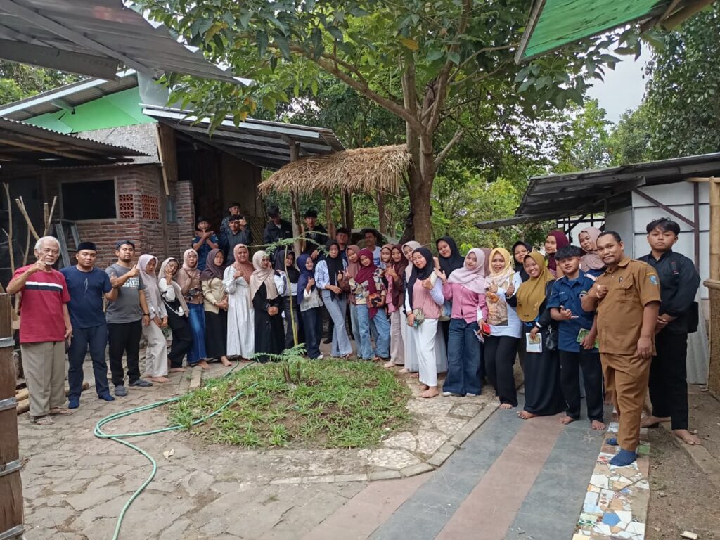 WhatsApp Image 2026-09-09 at 073059 - Mabur.co Group of men and women standing shoulder to shoulder outdoors for a large community photo in a yard with trees and simple buildings behind them.