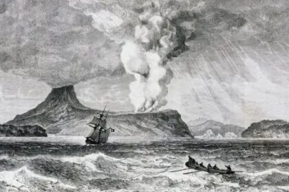 A volcanic eruption sends a tall plume into the sky as a sailing ship battles rough seas nearby.