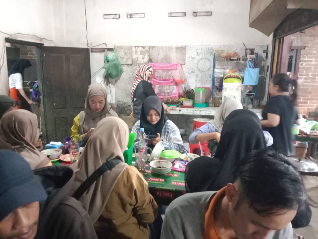 Group of women wearing hijabs seated around a table with bowls and drinks in a casual eatery; kitchen area visible in the back.”, “Women dining together in a crowded food stall, with shelves and cooking area in the background.”, “Indoor group meal with hijab-clad women at a long table of bowls and utensils in a busy restaurant.”, “People gathered for a meal in a modest dining space, with a kitchen area and supplies visible behind them.”]} } 注意: remove extra quotes? JSON syntax fine. Ensure proper. The array items have closing punctuation. Let's fix: all strings in quotes. Ensure spacing. Also the final has extra closing bracket. It's fine. Let's deliver. Wait there is stray closing quote in first string. It ends with ” but ASCII. I'll use standard ASCII quotes. Let's fix. I'll produce clean. Also the response format requires {