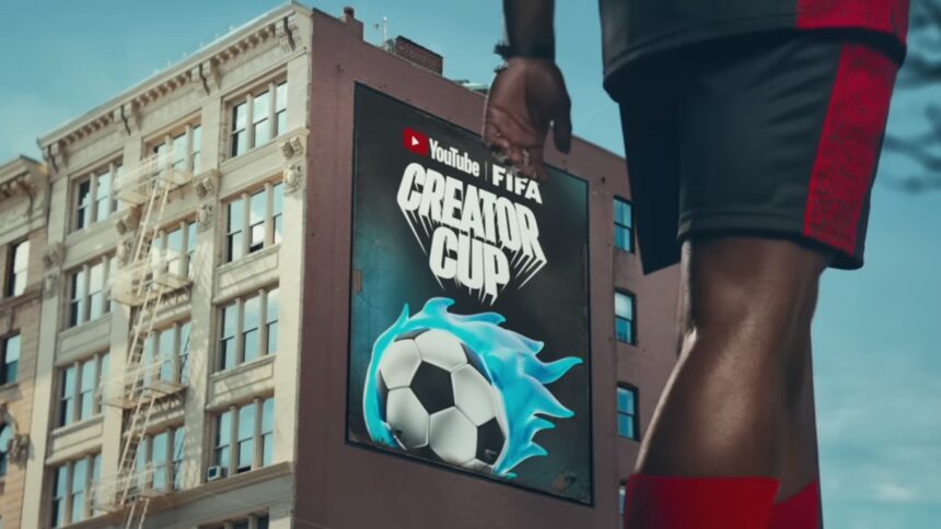 Billboard on a city building advertising YouTube FIFA Creator Cup with a blue-flamed soccer ball in the foreground Athlete’s leg visible for scale and action.
