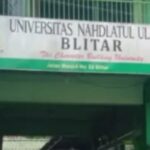 Signboard of Universitas Nahdlatul Ulama Blitar with a green canopy behind it