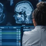 Medical professional in a white coat analyzes MRI brain scans projected on multiple screens.