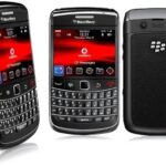 Three BlackBerry smartphones with physical QWERTY keyboards, shown from different angles, screens displaying Vodafone UI and red backgrounds.