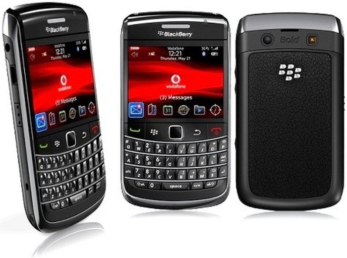 Three BlackBerry smartphones with physical QWERTY keyboards, shown from different angles, screens displaying Vodafone UI and red backgrounds.