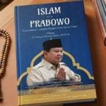 Blue book cover titled 'Islam ALA Prabowo' on a wooden desk, with a photo of a man in a tan uniform and a black cap, plus a wooden prayer bead lei beside it.