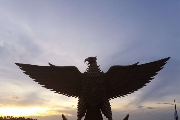 Silhouette of a large eagle statue with outstretched wings at sunset.