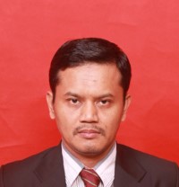 Portrait of a man in a dark suit and red tie against a red backdrop.