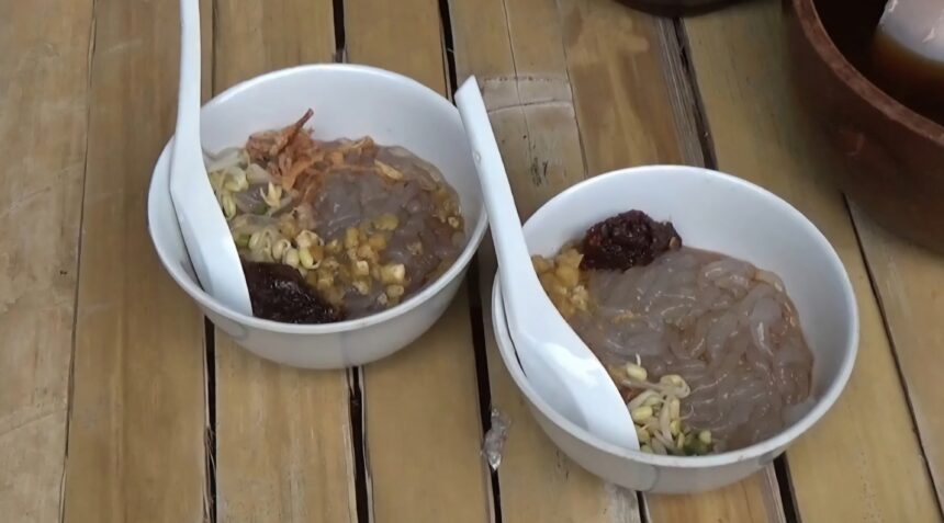 bbg - Mabur.co Two white bowls on a wooden table containing raw meat with pasta and vegetables, arranged for cooking or serving.