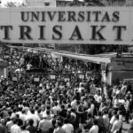 Crowd of students and protesters gathers outside the Universitas Trisakti campus gate in Indonesia, signaling a campus demonstration.