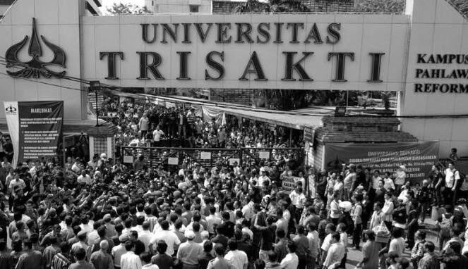 Crowd of students and protesters gathers outside the Universitas Trisakti campus gate in Indonesia, signaling a campus demonstration.