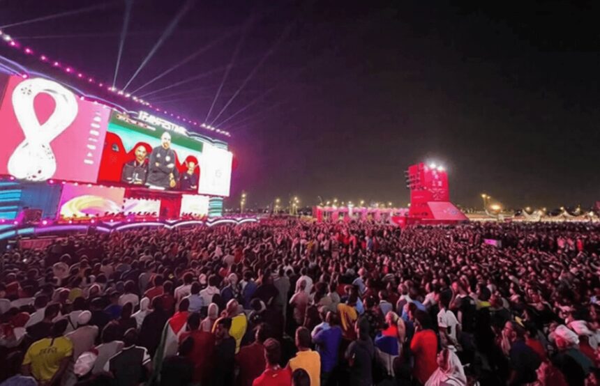 fan fest Piala Dunia 2022 by Qatar News Agency FIXX 2 - Mabur.co Massive outdoor concert crowd at night, watching a colorful stage with giant video screens.