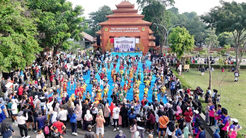 Crowd watches children in colorful traditional costumes perform a parade on a bright blue walkway in front of a brick stage at a cultural festival outdoors.