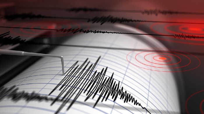 Seismograph recording seismic waves on paper with a needle and jagged lines, red circular patterns in the background.