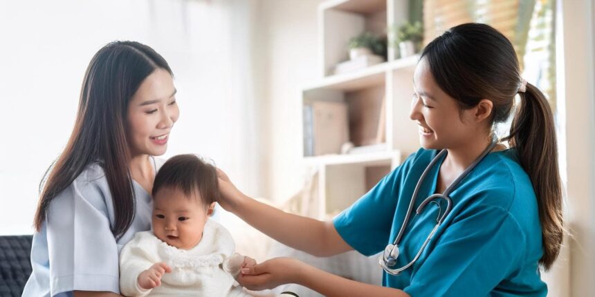 Pediatric nurse in teal scrubs smiling at a mother and her baby during a check-up in a clinic setting.