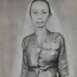 Black-and-white portrait of a woman wearing a veil and a medal-decorated dress, facing the camera.