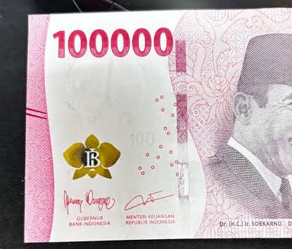 Indonesian 1,000,000-rupiah banknote with pink design, a yellow flower emblem, and a portrait on the right side.