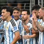 Argentina national team players celebrate together in their blue-and-white striped jerseys on the pitch.