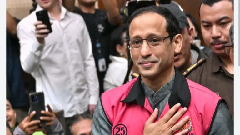 nadiem-makarim-U5R1F - Mabur.co Man in a pink vest with the number 25, hand on chest, amid a crowd of people taking photos behind him.