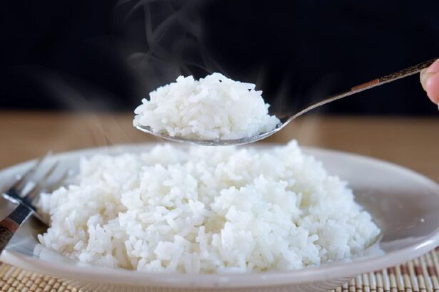 Steaming white rice being scooped from a plate with a spoon