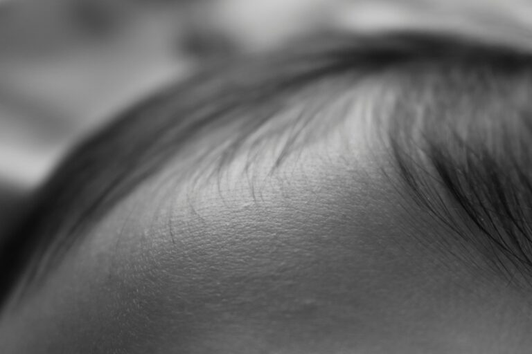 Extreme close-up of a closed eye, with eyelashes resting along the eyelid in grayscale.
