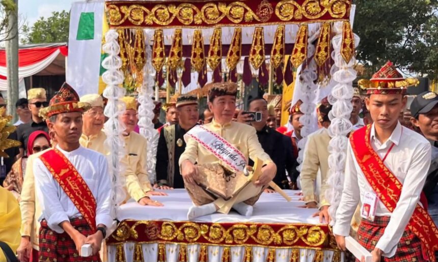 Group of men in traditional cream outfits with red sashes on a gold-decorated ceremonial float at a festival parade.