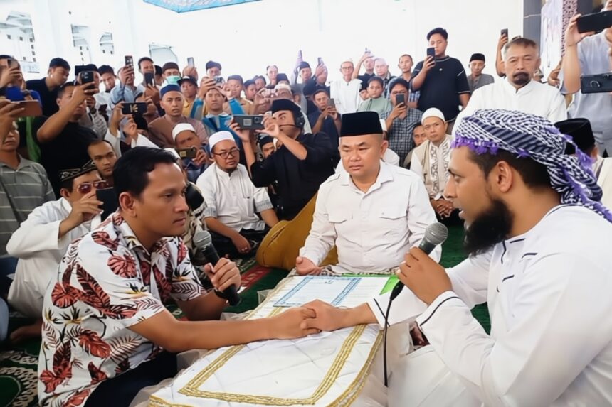 prosesi login by antaranews com - Mabur.co Two men shake hands across a low table as a crowd surrounds them, one holding a microphone, at a public gathering.