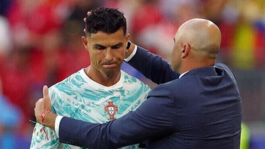 ronaldo subbed off vs Kroasia by REUTERS - Mabur.co Soccer player in a Portugal jersey being congratulated by a bald coach in a navy suit on the field.