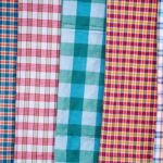 Six vertical strips of plaid fabric in blue, red, teal, yellow, and purple checks.
