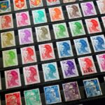 A sheet of assorted postage stamps arranged in diagonal rows, showing portraits, coats of arms, and crests in many colors on a dark background.