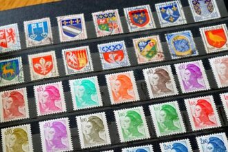 A sheet of assorted postage stamps arranged in diagonal rows, showing portraits, coats of arms, and crests in many colors on a dark background.