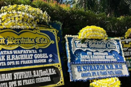 Three large flower-decorated condolence boards with blue and yellow motifs displayed outdoors.